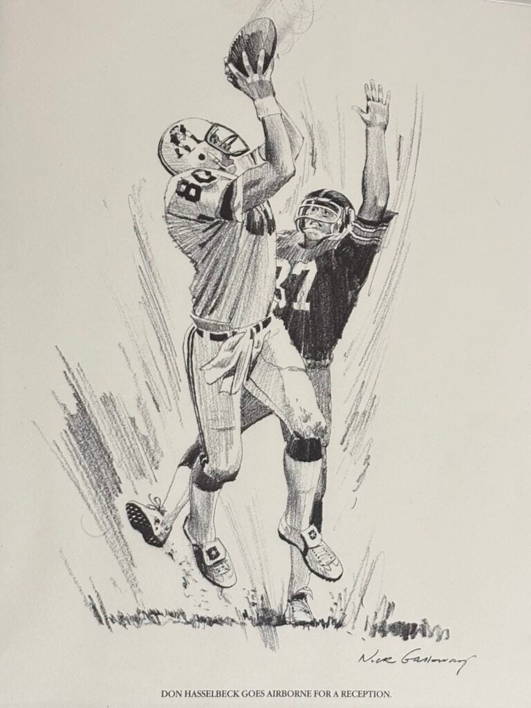 A print of a black and white drawing of Don Hasselbeck going up for a pass with a defender draped all over him.)