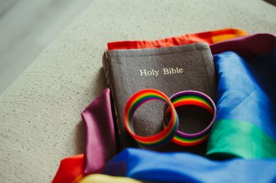 A Holy Bible lays on rainbow flags.