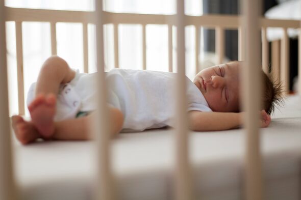 Newborn baby sleeping in cot