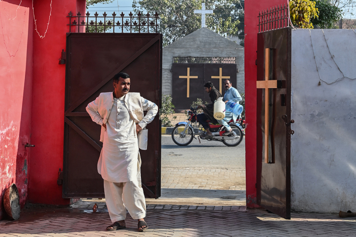A man stands at the entrance of the rehabilitated Presbyterian Church on a Christmas Day in Jaranwala on December 25, 2023. More than 80 Christian homes and 19 churches were vandalized in an hours-long riot in Jaranwala in Punjab province on August 16, 2023, after allegations that a Quran had been desecrated spread through the city.