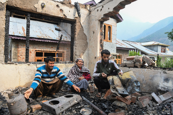 A family looks at the remains of their destroyed house following cross-border shelling between Pakistani and Indian forces in Salamabad uri village at the Line of Control (LoC).India's government said on May 8, 2025, that 13 civilians had been killed by Pakistani fire in 'ceasefire violations' along their de facto border since May 7, after violence escalated into artillery shelling following Indian strikes. India's foreign ministry said that all those killed were in the town of Poonch, with 59 others injured, the majority also in the town.