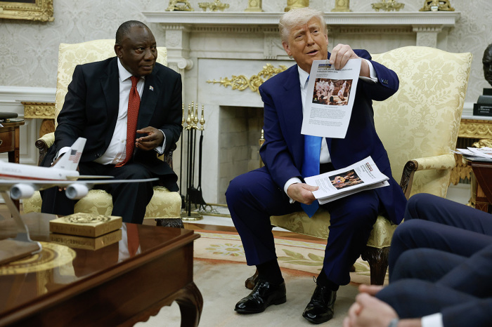 U.S. President Donald Trump holds up a printed article from 'American Thinker' while accusing South Africa President Cyril Ramaphosa of state-sanctioned violence against white farmers in South Africa during a press availability in the Oval Office at the White House on May 21, 2025, in Washington, D.C.