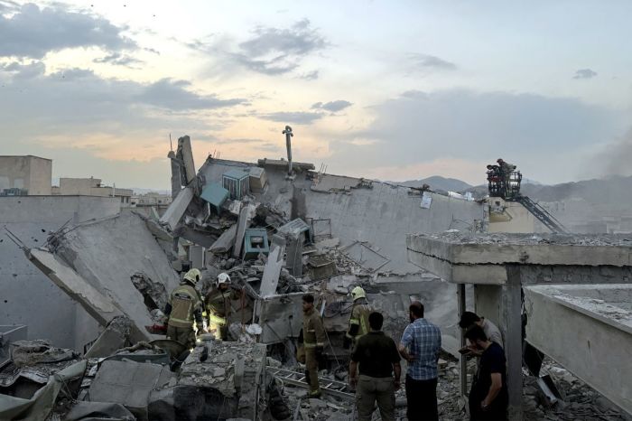 People and first-responders gather atop a building that was hit by an Israeli strike in Tehran on June 13, 2025. Israel hit about 100 targets in Iran on June 13, including nuclear facilities and military command centres and killing senior figures including the armed forces chief and top nuclear scientists.