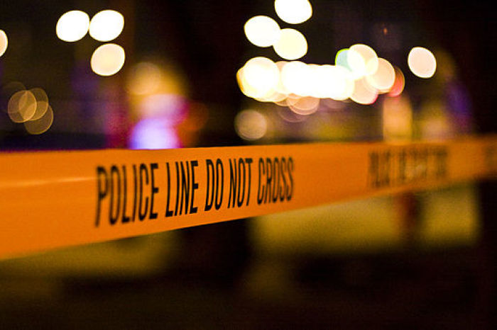 Police tape marks off the scene of a car crash.