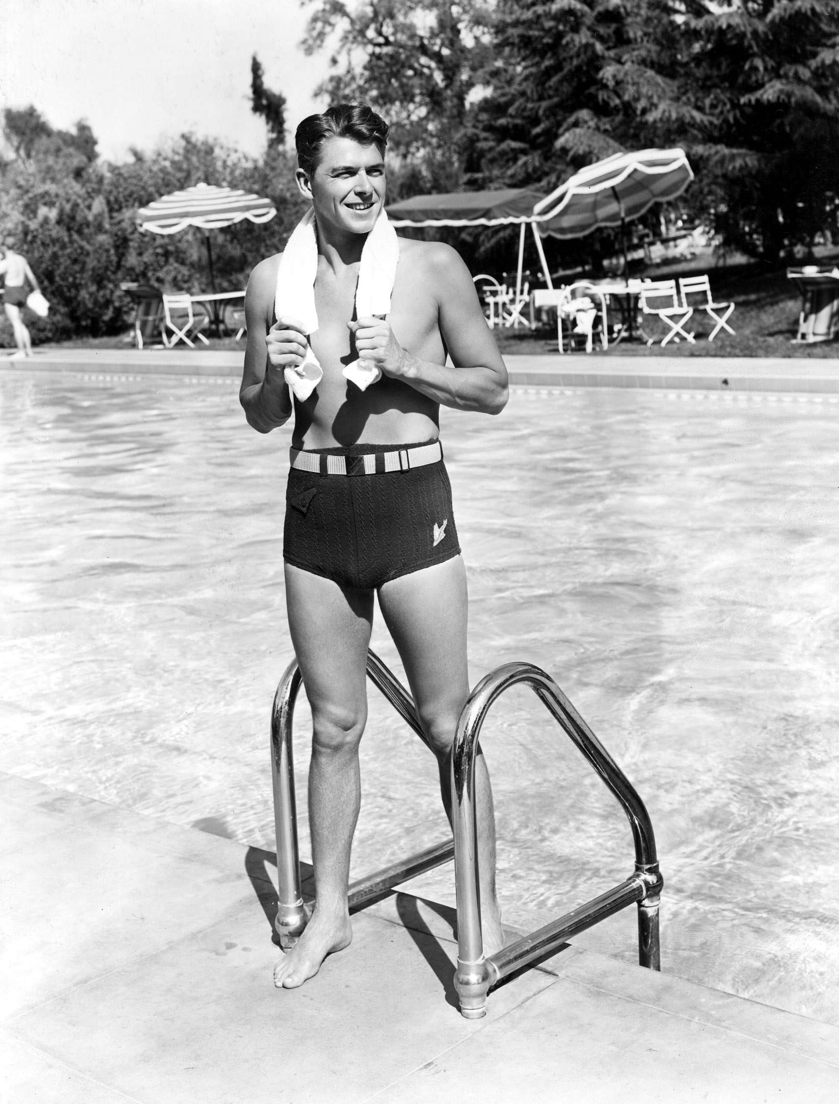 A photo of Ronald Reagan in a bathing suit standing next to a pool | Photo: Ronald Reagan, 1939; Keystone Press/Alamy