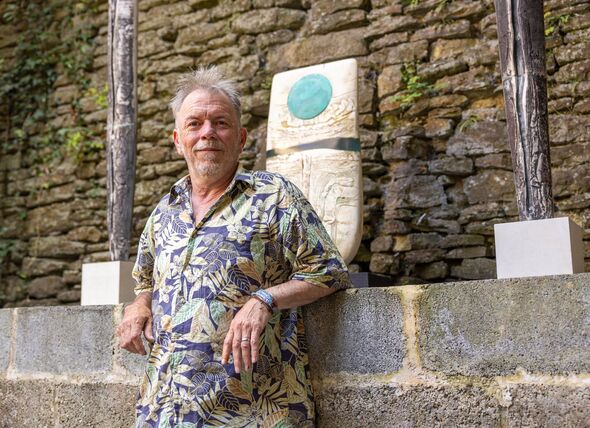 Garry Yoxall poses next to sculptures