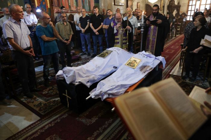 Archbishop Alexios blesses the bodies of Saad Salameh and Foumia Ayyad, killed earlier in an Israeli strike that hit the Holy Family church in Gaza City, during their funeral ceremony at the Saint Porphyrius Church on July 17, 2025. An Israeli strike on Gaza's only Catholic church killed three people on July 17, the Latin Patriarchate of Jerusalem said, as Israel said it 'never targets' religious sites and regretted any harm to civilians.