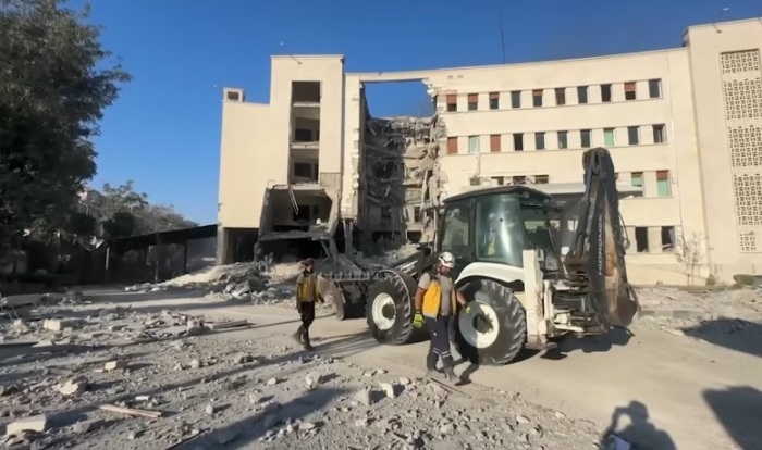 Workers walk in the aftermath of the Israel Defense Forces airstrikes on the headquarters of the Syrian Ministry of Defense in Damascus, Syria, on Wednesday, July 16, 2025.