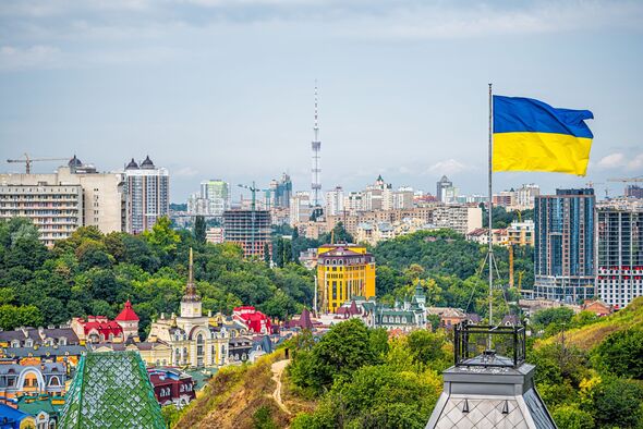 Kyiv, Ukraine cityscape of Kiev and Ukrainian flag waving in the wind during summer in Podil district and colorful new buildings