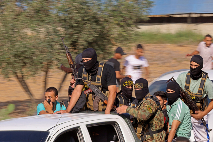 Palestinian militants move towards the border fence with Israel from Khan Yunis in the southern Gaza Strip on Oct. 7, 2023. Barrages of rockets were fired at Israel from the Gaza Strip at dawn as militants from the blockaded Palestinian enclave infiltrated Israel.