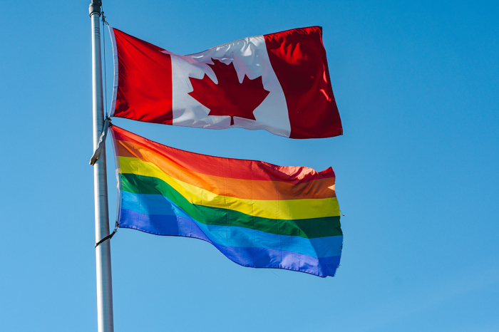 Rainbow flag flying together with Canadian flag in London, Ontario, Canada.