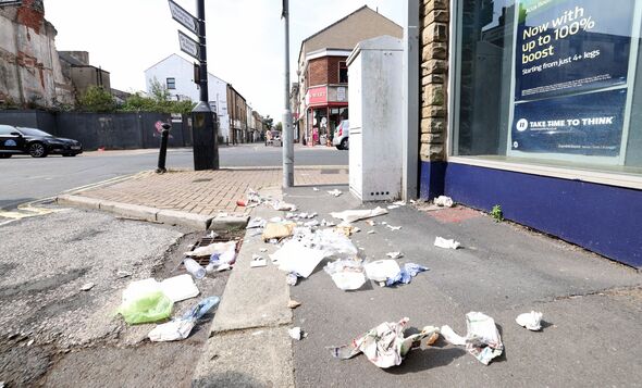 Run down and derelict shops and offices in the West End of Morecambe. Litter covering Regent Street.