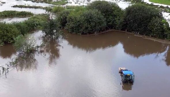 A large flooded field with a tractor visible among the water