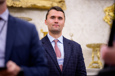 Turning Point USA co-founder Charlie Kirk stands in the back of the room as U.S. President Donald Trump speaks during a swearing in ceremony for interim U.S. Attorney for Washington, D.C. Jeanine Pirro in the Oval Office of the White House on May 28, 2025, in Washington, D.C.