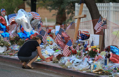 Cara Ediger visits the makeshift memorial for Charlie Kirk outside the headquarters of Turning Point USA on Sept. 19, 2025, in Phoenix, Arizona. Kirk, the CEO and co-founder of TPUSA, was shot and killed on Sept. 10 while speaking at an event for his 
