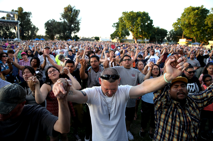 Attendees hold hands and pray as the Rev. Franklin Graham speaks during Franklin Graham's