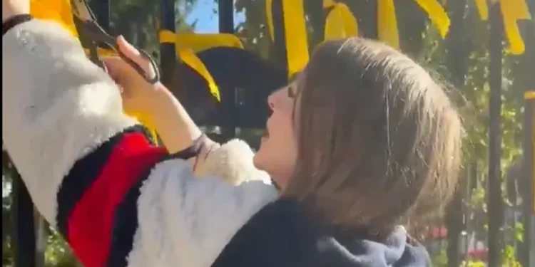 Husband of woman filmed cutting down memorial ribbons claims she was 'attacked by Mossad'