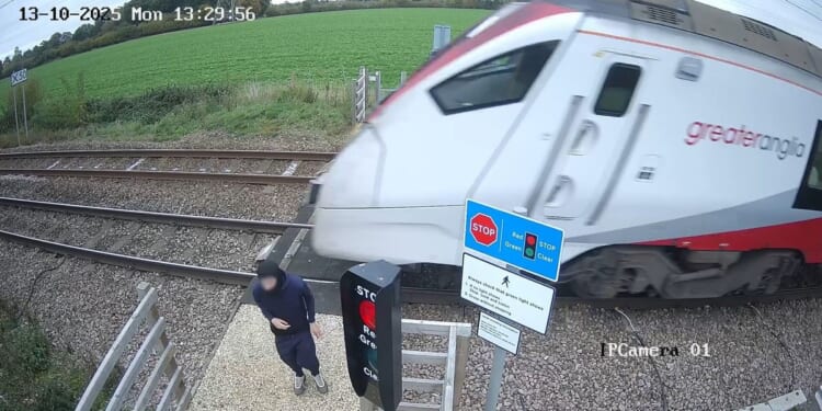 Watch gobsmacking moment teen CHEATS DEATH as he plays 'deadly game' next to 100mph train tracks