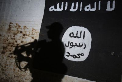 A member of the Iraqi forces walks past a mural bearing the logo of the Islamic State group in a tunnel that was reportedly used as a training centre by the jihadists, on March 1, 2017, in the village of Albu Sayf, on the southern outskirts of Mosul. Iraqi forces launched a major push on February 19 to recapture the west of Mosul from the Islamic State jihadist group, retaking the airport and then advancing north.