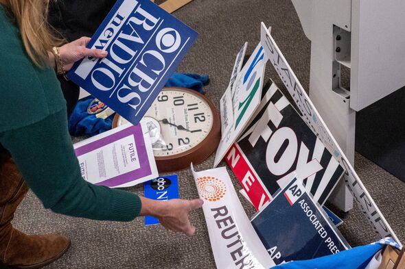 Washington Post reporter Tara Copp saves the name plaques from various news organizations as she and members of the media pack u