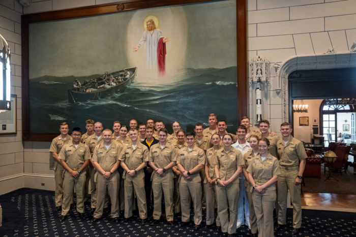 Midshipmen at the United States Merchant Marine Academy stand in front of the 'Christ on the Water' painting, which was restored to a place of prominence at Wiley Hall in a Sept. 29, 2025 ceremony.