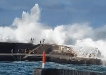 Tourist dead and nine injured after powerful wave drags swimmers out to sea at popular holiday hotspot