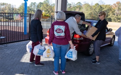 Volunteers with Solid Rock Church of Midland, Georgia, help distribute groceries during a giveaway event on Nov. 15, 2025.