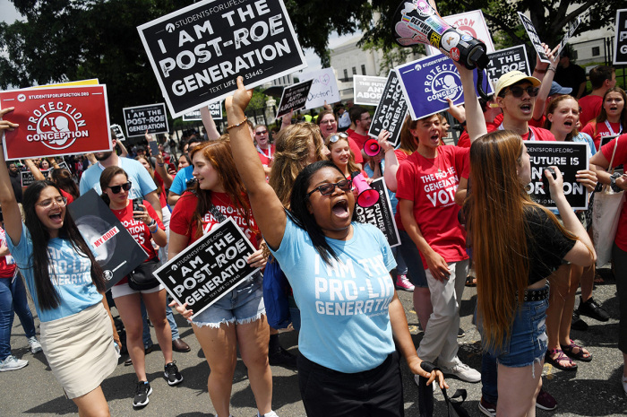 Pro-life campaigners celebrate near the U.S. Supreme Court in the streets of Washington, D.C., on June 24, 2022. - The U.S. Supreme Court on Friday reversed legalized abortion nationwide in one of the most divisive and bitterly fought issues in American political life. The court overturned the landmark 1973 Roe v. Wade decision and said individual states can permit or restrict the procedure themselves.