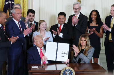 U.S. President Donald Trump, joined by first lady Melania Trump, members of his administration and foster care advocates, signs the