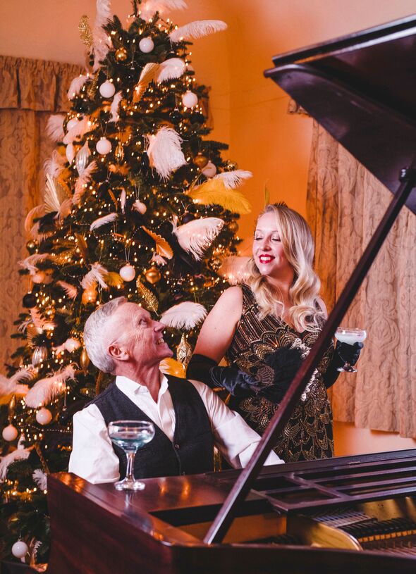 Two people at piano smiling at Coleton Fishacre Two people at piano smiling at Coleton Fishacre