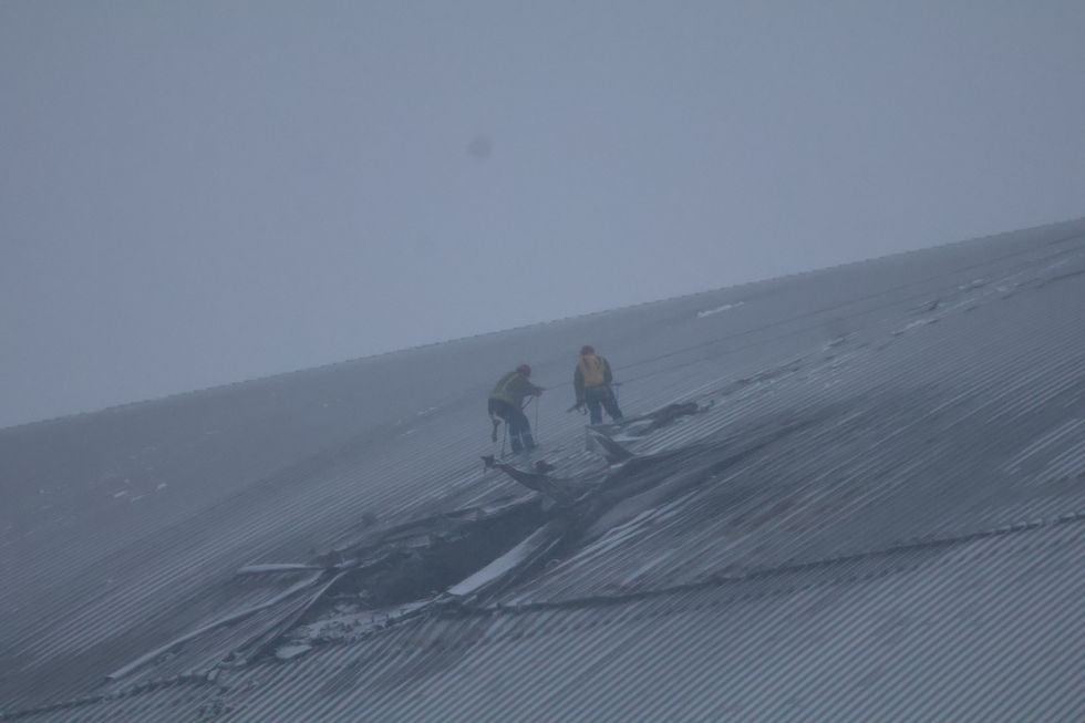 Ukrainian workers assessing damage on top of the New Safe Confinement in the winter snow