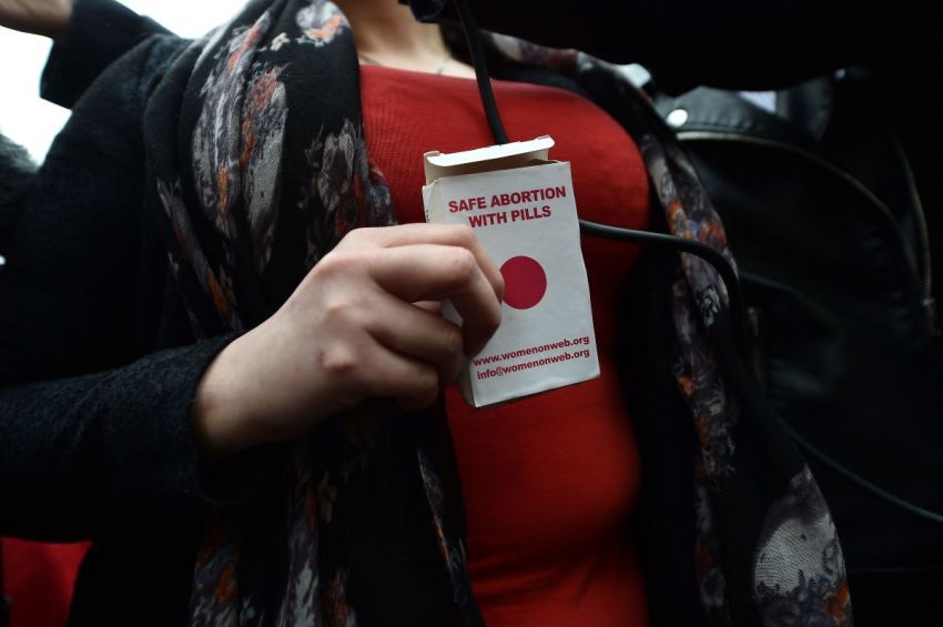 An unidentified woman displays an abortion pill packet after taking one of the pills as abortion rights campaign group ROSA, Reproductive Rights Against Oppression, Sexism and Austerity, distribute abortion pills from a touring bus on May 31, 2018, in Belfast, Northern Ireland.
