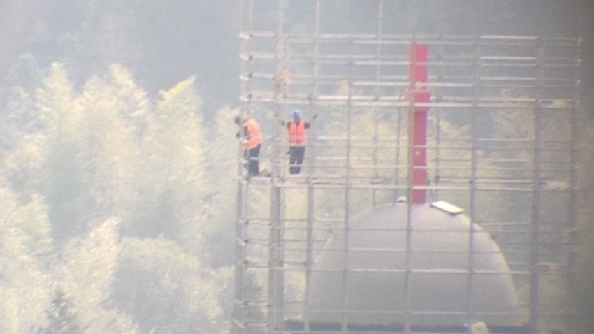 Workers stand on a scaffolding surrounding the cross atop Yayang Christian Church in Wenzhou, China, on Jan. 6, 2025.