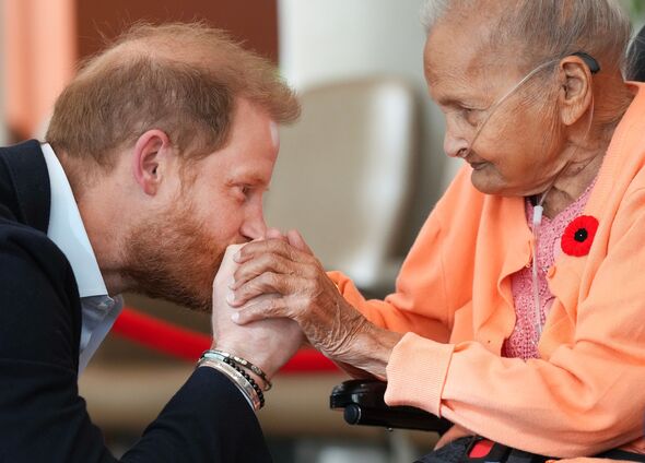 Prince Harry kisses a veteran's hands