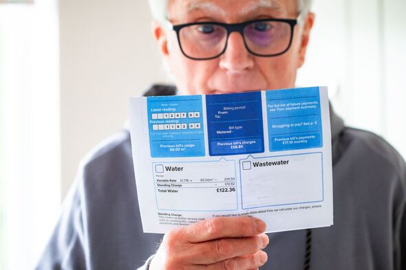 Worried senior man checking water bill at home