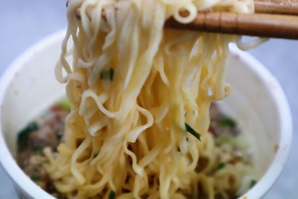 Eating cup ramen with chopsticks