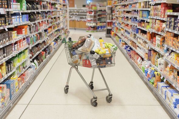 Full shopping cart in supermarket aisle Full shopping cart in supermarket aisle