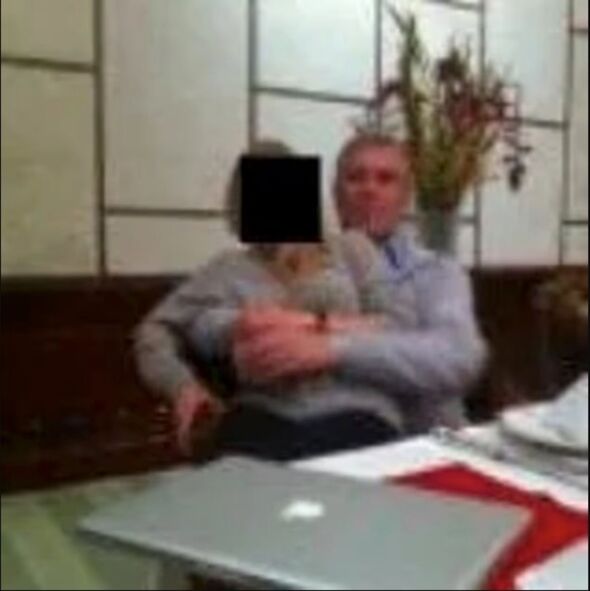 A blurry photo of a woman sat on a man's lap