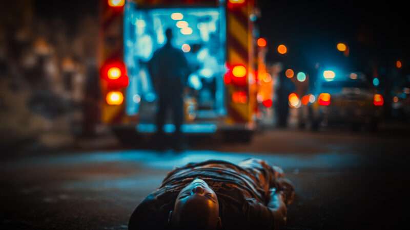 AI-generated image of a black man on the ground as somebody else is loaded into an ambulance. | Illustration: Midjourney