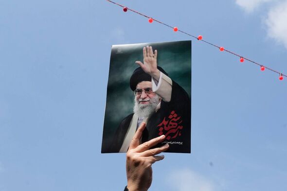 A woman holds up a poster of the late Iranian Supreme Leader Ayatollah Ali Khamenei as she attends the funeral procession for se