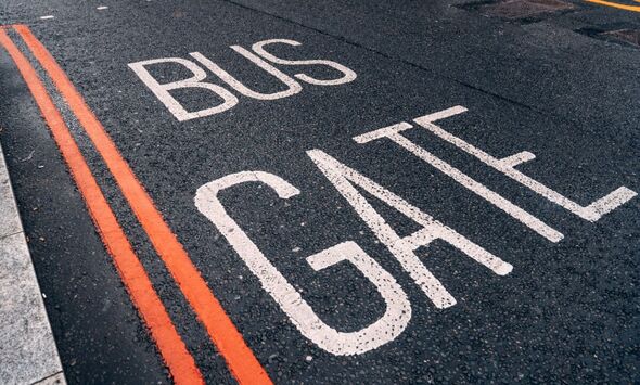 'Bus Gate' is painted in white on a road with double red lines near a kerb