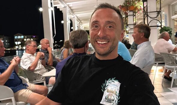 Mr McEntee smiles sitting outside at restaurant