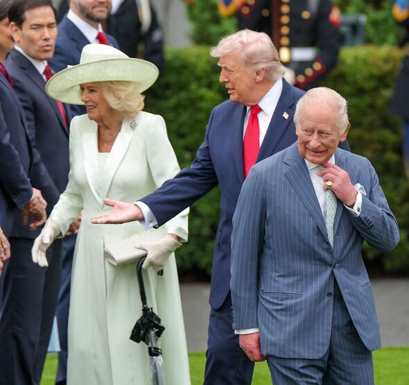 Donald Trump steps in front of Queen Camilla to shakes hands with officials