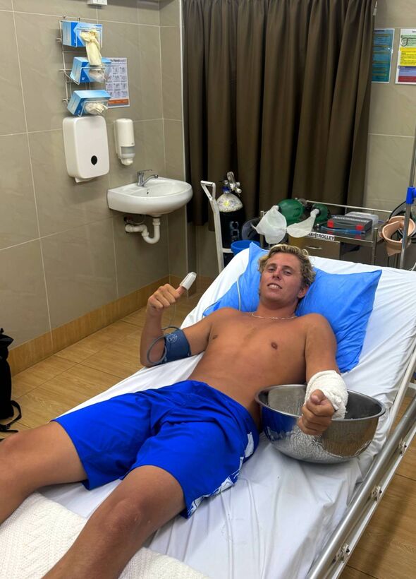 A man with a bandaged arm in a hospital bed