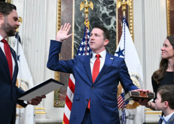 (L/R) US Vice President JD Vance swears in Colin McDonald as Assistant Attorney General for the National Fraud Enforcement Division as McDonald's wife Janessa holds the Bible in the Eisenhower Executive Office Building, next to the White House in Washington, DC on April 1, 2026. McDonald will be the first Assistant Attorney General for the Department of Justice's newly created National Fraud Enforcement Division. (Photo by Mandel NGAN / AFP via Getty Images)