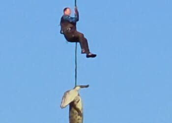 Police officer dangles over crocodile-infested waters in bid to retrieve human remains