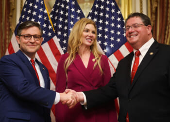 Rep. Mike Johnson (R-LA) (L) participates in a ceremonial swearing-in with Rep. Randy Fine (R-FL) (R) with wife Wendy Fine (C).