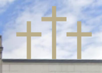 Three golden crosses stand on top of a building.