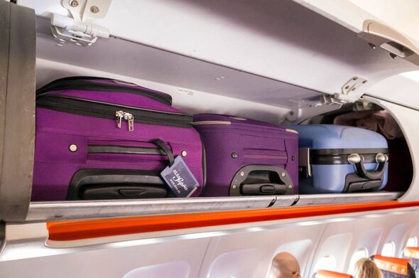 Luggage compartment in an airplane with various suitcases stored inside, showcasing the organized arrangement of travel essentia